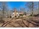 Inviting ranch-style home featuring a brick chimney, complemented by bare trees in a natural setting at 135 Flat Creek Ct, Fayetteville, GA 30214