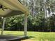 Covered patio overlooking the backyard, featuring lush green grass and a serene wooded backdrop at 85 Crabapple Ridge Dr, Oxford, GA 30054