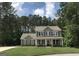 Charming two-story home with a well-manicured lawn and inviting front porch surrounded by lush trees at 85 Crabapple Ridge Dr, Oxford, GA 30054