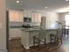 Bright kitchen featuring white cabinets, stainless steel appliances, and a center island with barstool seating at 85 Crabapple Ridge Dr, Oxford, GA 30054