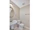 Well-lit half-bathroom featuring a pedestal sink, toilet, and neutral decor at 175 Ashley Dr, Fayetteville, GA 30214