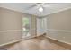 Empty bedroom featuring wood-look floors, a ceiling fan, and a window with tree views at 175 Ashley Dr, Fayetteville, GA 30214