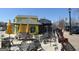 Outdoor seating area of a vibrant yellow and black restaurant with tables, chairs, and artistic mural at 1876 Sw Sandtown Sw Rd, Atlanta, GA 30311