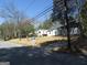 Neighborhood street scene with houses, well-manicured lawns, and a street number on a brick base at 1876 Sw Sandtown Sw Rd, Atlanta, GA 30311