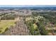 Wide aerial shot showcasing a neighborhood surrounded by expansive woodlands and open fields at 850 Coan Dr, Locust Grove, GA 30248