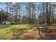 Spacious backyard featuring a fire pit and outbuildings in a wooded setting at 850 Coan Dr, Locust Grove, GA 30248