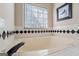Well-lit bathroom featuring a large bathtub beneath a window at 850 Coan Dr, Locust Grove, GA 30248