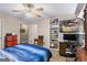 Bedroom features a ceiling fan, TV, bookcase, and a bed with blue covers at 850 Coan Dr, Locust Grove, GA 30248