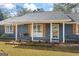 Inviting front porch with a swing, classic wooden shutters, and well-maintained landscaping at 850 Coan Dr, Locust Grove, GA 30248