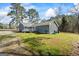Gray house with a wooden deck and green yard in a wooded area at 850 Coan Dr, Locust Grove, GA 30248
