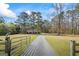 A charming house with a long driveway, surrounded by lush trees and a clear blue sky at 850 Coan Dr, Locust Grove, GA 30248