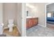 Bathroom with dual sinks, stained cabinets, and a toilet located in a separate room at 7019 Diamond Dr, Rex, GA 30273