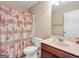 Bathroom features a vanity with marble countertop and a shower with a rose-patterned curtain at 7019 Diamond Dr, Rex, GA 30273