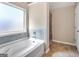 Bathtub with tile surround and a view out the window, as well as a glass-enclosed shower at 7019 Diamond Dr, Rex, GA 30273