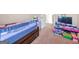 Bedroom features neutral walls, carpet, a bed with guard rail, and a shelf with toys at 7019 Diamond Dr, Rex, GA 30273