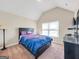 Bedroom features neutral walls, carpet, and a dark wood bed frame with bright bedding at 7019 Diamond Dr, Rex, GA 30273