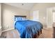 Bedroom features neutral walls, carpet, and a dark wood bed frame with bright blue bedding at 7019 Diamond Dr, Rex, GA 30273