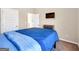 Bedroom features neutral walls, carpet, and a dark wood bed frame with bright blue bedding at 7019 Diamond Dr, Rex, GA 30273