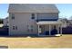 Back exterior view of home with gray siding, well-maintained lawn, and covered patio at 7019 Diamond Dr, Rex, GA 30273