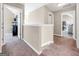 Well-lit hallway with neutral paint, carpet flooring and white trim leading to various rooms in the home at 7019 Diamond Dr, Rex, GA 30273