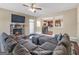Bright living room featuring a stone fireplace, a ceiling fan, and a comfortable sectional sofa at 7019 Diamond Dr, Rex, GA 30273
