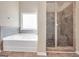 Walk-in tiled shower is adjacent to a soaking tub in this primary bathroom at 7019 Diamond Dr, Rex, GA 30273