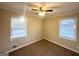 This cozy bedroom features neutral walls, a ceiling fan, and two windows at 20 Maddox Dr, Locust Grove, GA 30248