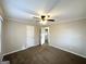Bedroom features neutral walls, carpet floors, a ceiling fan, and a door to an ensuite bathroom at 20 Maddox Dr, Locust Grove, GA 30248