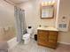 Well-lit bathroom featuring a single sink, toilet, and a bathtub with a striped shower curtain at 345 Gaelic Way, Tyrone, GA 30290