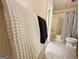 Bright bathroom featuring neutral walls, tiled floors, and a bathtub with a striped shower curtain at 345 Gaelic Way, Tyrone, GA 30290