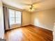 Bedroom with hardwood flooring, a ceiling fan, and a large window at 345 Gaelic Way, Tyrone, GA 30290