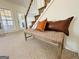 Entryway bench seat with decorative pillows next to staircase and white trimmed doors at 345 Gaelic Way, Tyrone, GA 30290