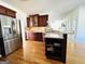 Well-lit kitchen featuring stainless steel refrigerator, wood cabinets, and an eat-in kitchen bar at 345 Gaelic Way, Tyrone, GA 30290