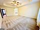 Expansive main bedroom with tray ceiling, neutral carpet, and access to other rooms at 345 Gaelic Way, Tyrone, GA 30290