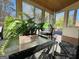 Inviting sun room with a glass table and a large potted fern, blending indoor comfort with outdoor views at 345 Gaelic Way, Tyrone, GA 30290