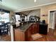 Open kitchen with a central island, dark cabinets, stainless steel appliances, and a dining area at 108 Caraway Rd, Locust Grove, GA 30248