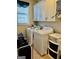 Laundry area with white cabinets, front load machines, and storage at 108 Caraway Rd, Locust Grove, GA 30248