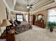 Generous main bedroom featuring a four-poster bed, a tray ceiling, and lots of natural light at 108 Caraway Rd, Locust Grove, GA 30248