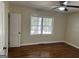 This bright bedroom features hardwood floors, a window and neutral paint at 718 N Hairston Rd, Stone Mountain, GA 30083