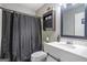 Well-lit bathroom features a black shower curtain, storage space, and a white sink at 4247 Windward Ln, Norcross, GA 30093