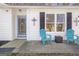 Inviting front porch area with blue chairs, stylish decor, and a glass-paneled entry door at 4247 Windward Ln, Norcross, GA 30093