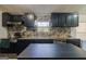 Stylish kitchen featuring black cabinetry, stainless steel appliances, and a sleek island with marble backsplash at 105 Woodfield Rd, Covington, GA 30014