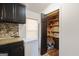 Convenient pantry with organized shelving, stocked with essentials next to black cabinets and white freezer at 105 Woodfield Rd, Covington, GA 30014
