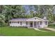 Charming single-story home with a welcoming porch, surrounded by lush greenery and a well-manicured lawn at 3395 Longleaf Dr, Decatur, GA 30032