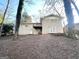 Backyard view of a brick house with a deck and mature trees in a natural setting at 3558 Turner Heights Dr, Decatur, GA 30032