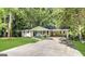 Charming single-story home with a large driveway and lush green lawn surrounded by mature trees at 3558 Turner Heights Dr, Decatur, GA 30032