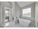 Elegant bathroom with a soaking tub, marble tile, and a window, offering a luxurious and relaxing experience at 253 Summit View Dr, Mcdonough, GA 30253