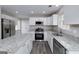 Bright kitchen with white cabinets, granite countertops, stainless steel appliances, and center island at 253 Summit View Dr, Mcdonough, GA 30253