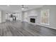 Open-concept living area with modern fireplace, large windows, and stylish gray wood flooring at 253 Summit View Dr, Mcdonough, GA 30253