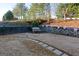 Spacious backyard featuring a stone paver path, white bench, tiered planters, and lush greenery at 4030 Cresent Walk Ne Ln, Suwanee, GA 30024
